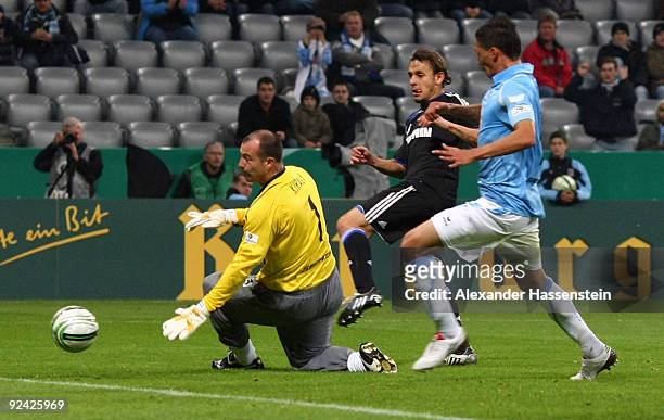 Rafinha of Schalke scores his team's first goal against goalkeeper Gabor Kiraly of 1860 and his team mate Jose Holebas during the DFB Cup round of 16...