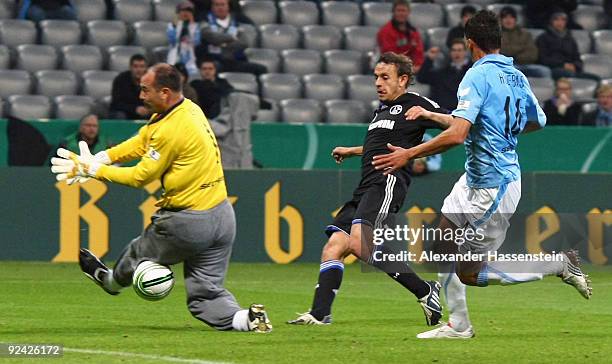 Rafinha of Schalke scores his team's first goal against goalkeeper Gabor Kiraly of 1860 and his team mate Jose Holebas during the DFB Cup round of 16...