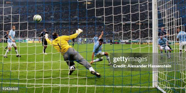 Benedikt Hoewedes of Schalke scores his team's second goal against goalkeeper Gabor Kiraly of 1860 during the DFB Cup round of 16 match between 1860...