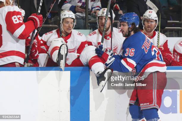 Mats Zuccarello of the New York Rangers pushes Xavier Ouellet of the Detroit Red Wings into the bench after a hit at Madison Square Garden on...