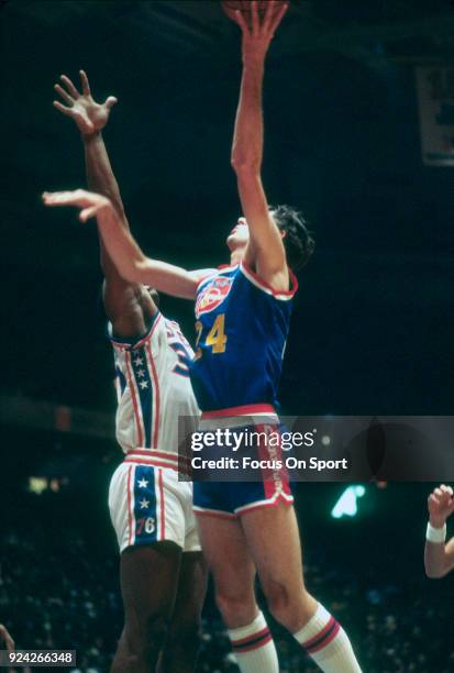 Bobby Jones of the Denver Nuggets shoots over George McGinnis of the Philadelphia 76ers during an NBA basketball game circa 1977 at The Spectrum in...