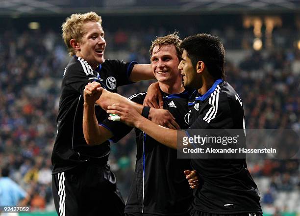 Benedikt Hoewedes of Schalke celebrates after scoring his team's third goal with team mates Lewis Holtby and Carlos Zambrano during the DFB Cup round...