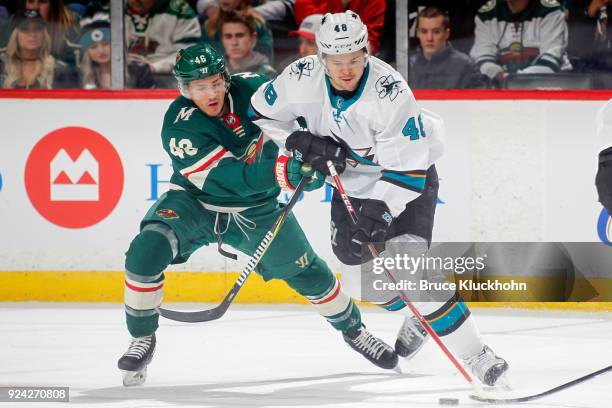 Tomas Hertl of the San Jose Sharks handles the puck with Jared Spurgeon of the Minnesota Wild defending during the game at the Xcel Energy Center on...