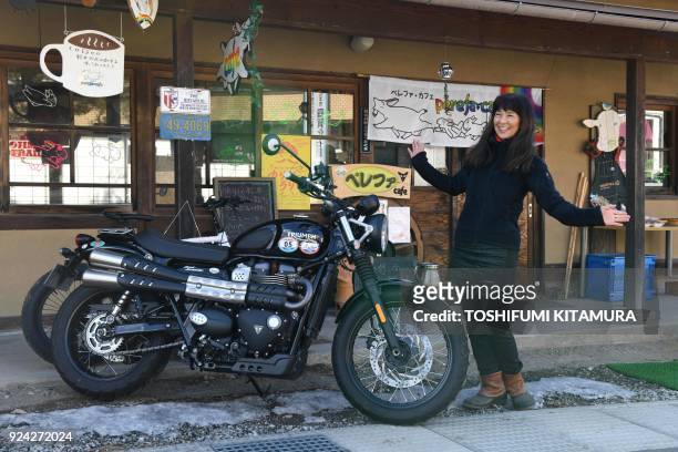 This February 23, 2018 picture shows Reiko Miyoshi a motorcyclist, an essayist and cafe owner, posing for a picture beside her current motorcycle, a...