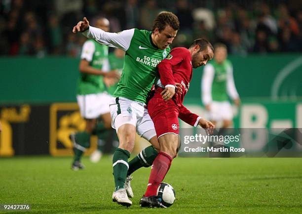 Philipp Bargfrede of Bremen and Fabian Mueller of Kaiserslautern compete for the ball during the DFB Cup round of 16 match between between Werder...