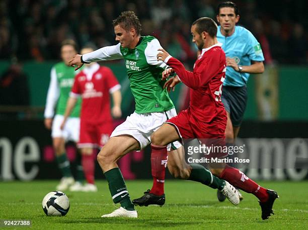 Torsten Oehrl of Bremen and Fabian Mueller of Kaiserslautern compete for the ball during the DFB Cup round of 16 match between between Werder Bremen...