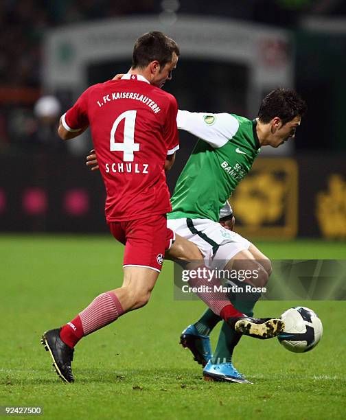 Mesut Oezil of Bremen and Bastian Schulz of Kaiserslautern compete for the ball during the DFB Cup round of 16 match between between Werder Bremen...