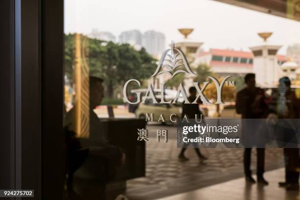 Signage for the Galaxy Macau casino and hotel is displayed on a window at the resort, developed by Galaxy Entertainment Group Ltd., in Macau, China,...