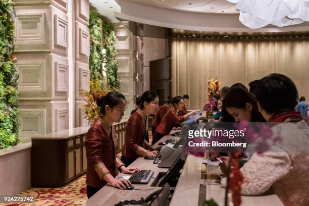 Employees assist customers at reception counters in the Galaxy Macau casino and hotel, developed by Galaxy Entertainment Group Ltd., in Macau, China,...