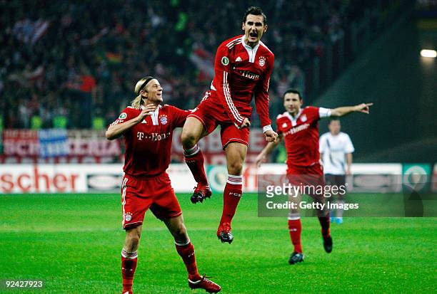 Miroslav Klose celebrates his team's second goal with team mates Anatoliy Timoshchuk and Mark van Bommel during the DFB Cup round of 16 match between...