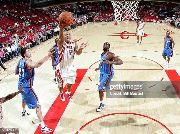 Will Conroy of the Houston Rockets shoots a layup between Byron Mullens and D.J. White of the Oklahoma City Thunder during a preseason game at Toyota...