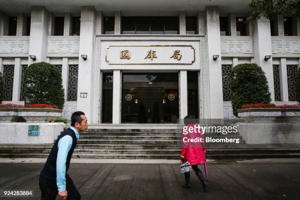 Pedestrians walk past the Department of the Treasury at the Taiwan Central Bank headquarters building in Taipei, Taiwan, on Monday, Feb. 26, 2018....