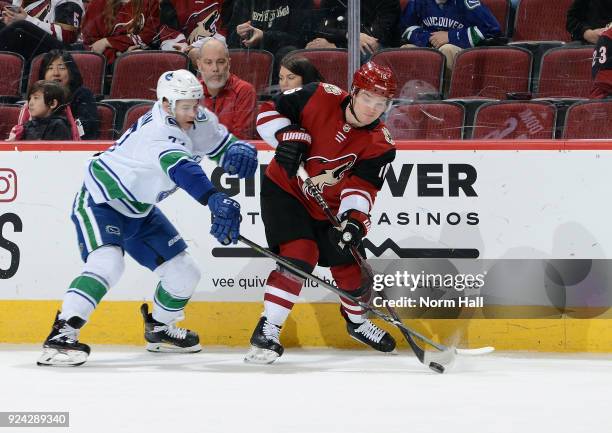 Max Domi of the Arizona Coyotes passes the puck away from Nikolay Goldobin of the Vancouver Canucks during the second period at Gila River Arena on...