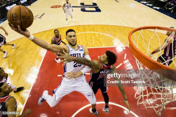 Ben Simmons of the Philadelphia 76ers dunks over Kelly Oubre Jr. #12 of the Washington Wizards during the second half at Capital One Arena on...