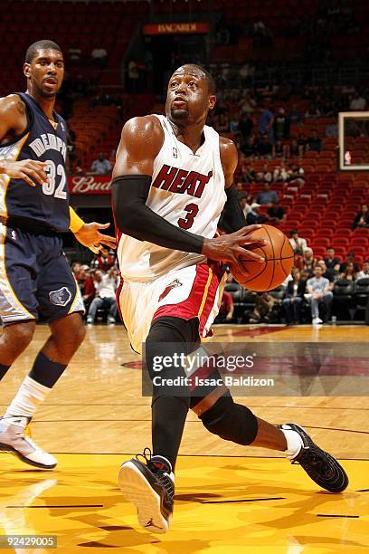 Dwyane Wade of the Miami Heat drives to the basket past O.J. Mayo of the Memphis Grizzlies during a preseason game at American Airlines Arena on...