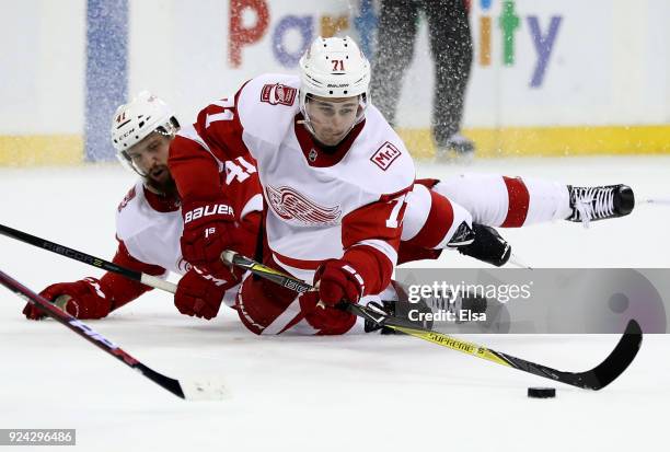 Dylan Larkin of the Detroit Red Wings tries to pass the puck as he collides with teammate Luke Glendening of the Detroit Red Wings in the third...
