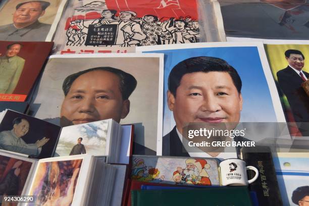 Posters of Chinese President Xi Jinping and late communist leader Mao Zedong are seen at a market in Beijing on February 26, 2018. Xi Jinping's...