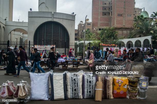Street vendors sell items in an alley off the Al-Attaba market in the centre of the Egyptian capital Cairo on February 21, 2018. - While Sisi's...