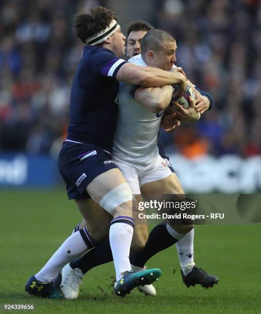 Mike Brown of England is tackled by Hamish Watson during the NatWest Six Nations match between Scotland and England at Murrayfield on February 24,...