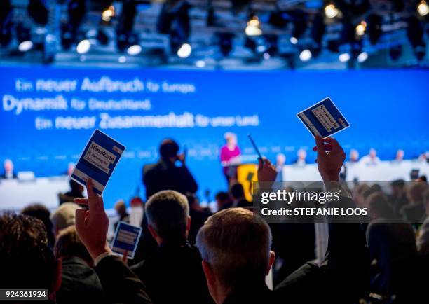 Delegates hold up their voting cards during the party congress of the conservative Christian Democratic Union on February 26, 2018 in Berlin. The CDU...