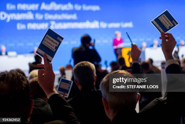 Delegates hold up their voting cards during the party congress of the conservative Christian Democratic Union on February 26, 2018 in Berlin. The CDU...