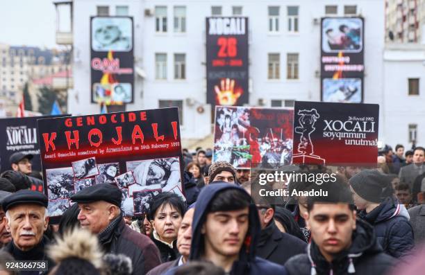 People holding banners and flags arrive to place carnations at "Ana feryadi" monument, during the 26th anniversary of 'Khojaly Massacre', which...