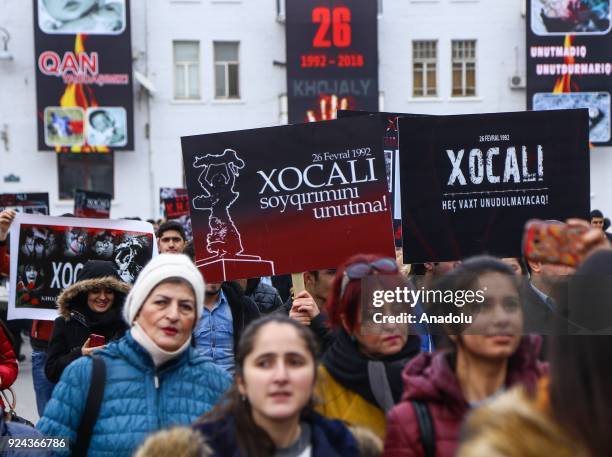 People holding banners and flags arrive to place carnations at "Ana feryadi" monument, during the 26th anniversary of 'Khojaly Massacre', which...