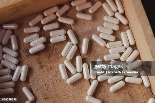 white pills in wooden box - child proof imagens e fotografias de stock