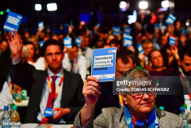 Delegates of the conservative Christian Democratic Union party hold up their voting cards during the CDU party congress on February 26, 2018 in...