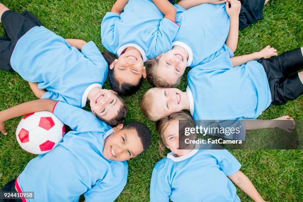 soccer players laying in grass - fat soccer players stock pictures, royalty-free photos & images