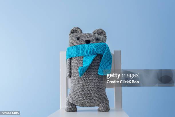 handmade crocheted teddy bear with a blue scarf - blue bear stock-fotos und bilder