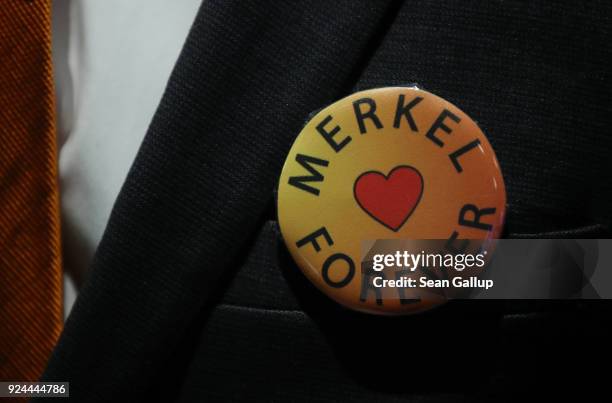 Delegate wears a button the reads: "Merkel Forever" in reference to German Chancellor and Chairwoman of the German Christian Democrats Angela Merkel...