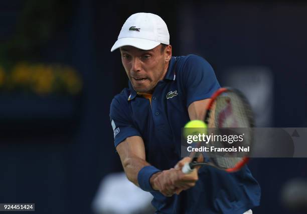Roberto Bautista Agut of Spain plays a backhand in his match against Florian Mayer of Germany during day one of the ATP Dubai Duty Free Tennis...