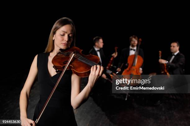 young woman in black dress playing violin - beautiful woman violinist stock pictures, royalty-free photos & images