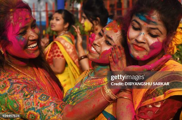 Indian students smear coloured powder during an event to celebrate the Hindu festival of Holi in Kolkata on February 26, 2018. - Holi, the popular...