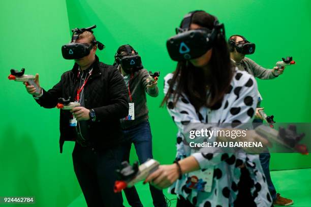 People try the HTC VIVE virtual reality glasses at the Mobile World Congress , the world's biggest mobile fair, on February 26, 2018 in Barcelona....