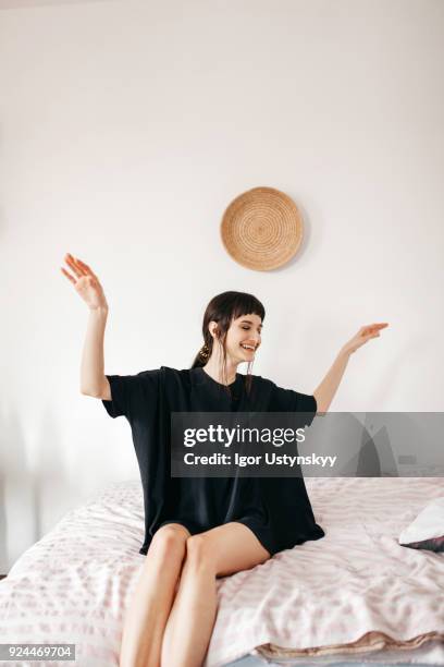 young happy woman dancing on bed - chica bailando en pijama fotografías e imágenes de stock