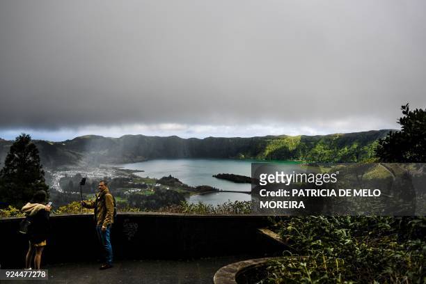 Tourists take pictures of Sete Cidades lagoon at an abandoned hotel that has become one of the most visited viewpoints in Sao Miguel island, Azores,...
