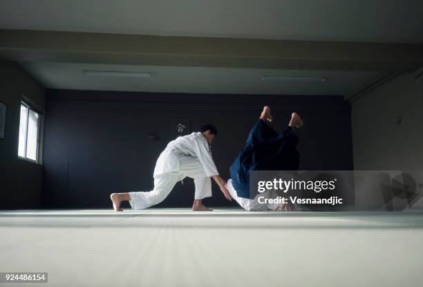 Adolescente muchacho con su sansei practicando en el dojo