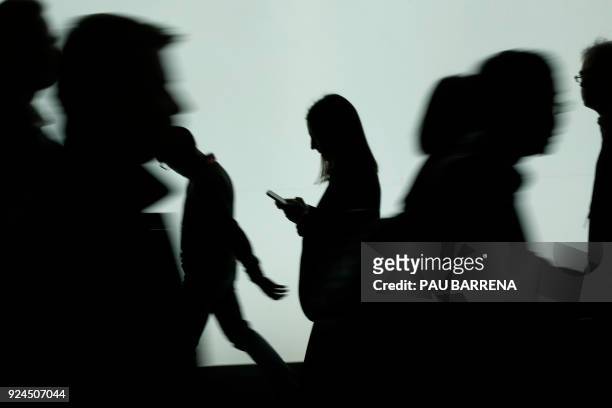 Woman looks at the phone at the Mobile World Congress , the world's biggest mobile fair, on February 26, 2018 in Barcelona. The Mobile World Congress...