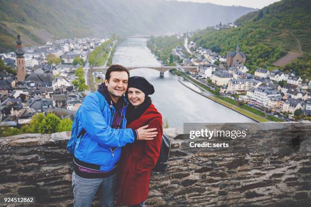 cheerful young couple enjoying visiting city view of cochem town in germany - cochem moselle stock pictures, royalty-free photos & images