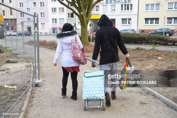 People leave the 'Essener Tafel' in Essen, Germany on February 26, 2018. German security services said on February 26, they were searching for...