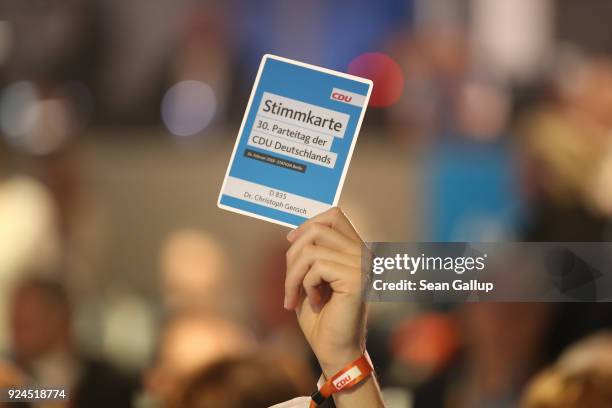 Delegate holds up a card to vote against the coalition contract with the German Social Democrats during the 30th German Christian Democrats party...