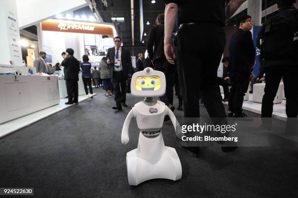 Robelf, a multi-camera home security robot, waves as it travels along the hall floor during the opening day of the Mobile World Congress in...