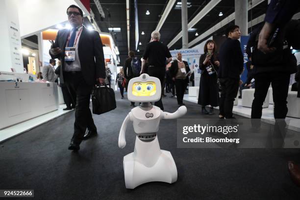 Robelf, a multi-camera home security robot, waves as it travels along the hall floor during the opening day of the Mobile World Congress in...