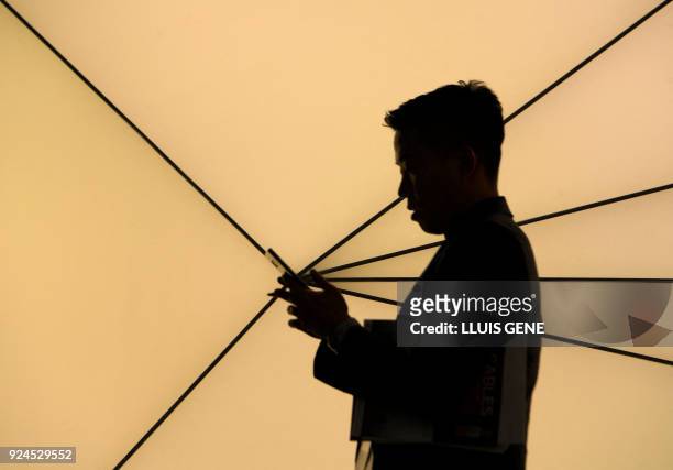Person uses a smartphone at the Mobile World Congress , the world's biggest mobile fair, on February 26, 2018 in Barcelona. - The Mobile World...