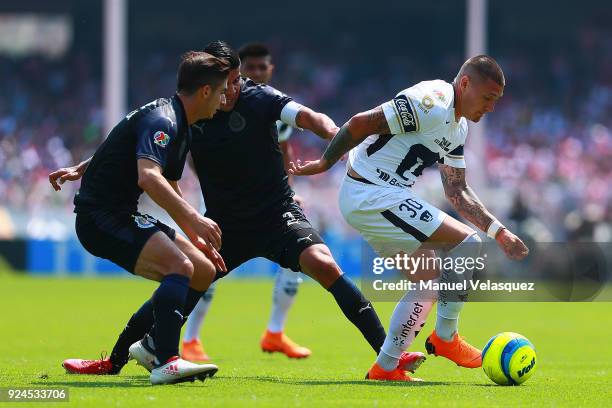 Nicolas Castillo of Pumas struggles for the ball with Isaac Brizuela and Carlos Salcido of Chivas during the 9th round match between Pumas UNAM and...