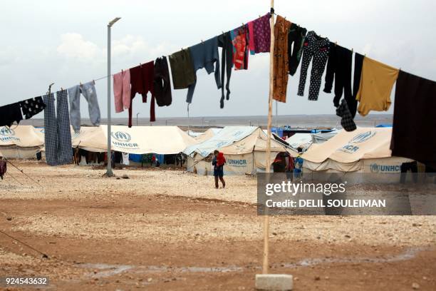 Displaced Syrians, who fled their homes in Deir Ezzor city, walk around a refugee camp in Syria's northeastern Hassakeh province on February 26, 2018.