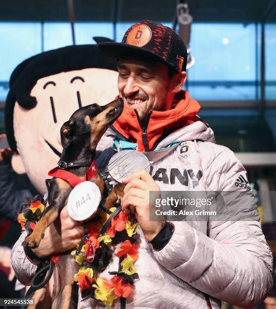 Dennis Endras of the German ice hockey team is welcomed by his dog Tia during the welcome ceremony for the members of Team Germany after their return...
