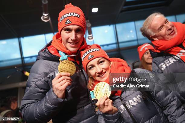 Figure skaters Aljona Savchenko and Bruno Massot pose with their gold medals during the welcome ceremony for the members of Team Germany after their...